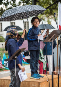 Photo of Naeil reading his poetry at an MVPJ Peace Picnic
